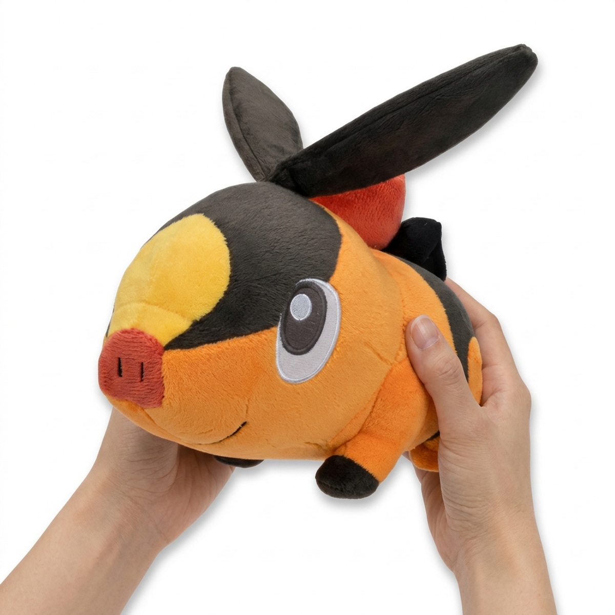 Tepig Pluszak trzymany w ręku